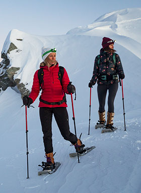 women snowshoeing on a mountain