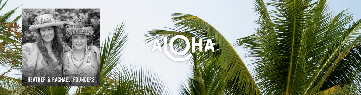 A tropical-themed banner or sign featuring the word 'ALOHA' in white stylized text, a black-and-white inset photo of two women labeled 'HEATHER & RACHEL FOUNDER,' and green palm leaves against a pale sky.