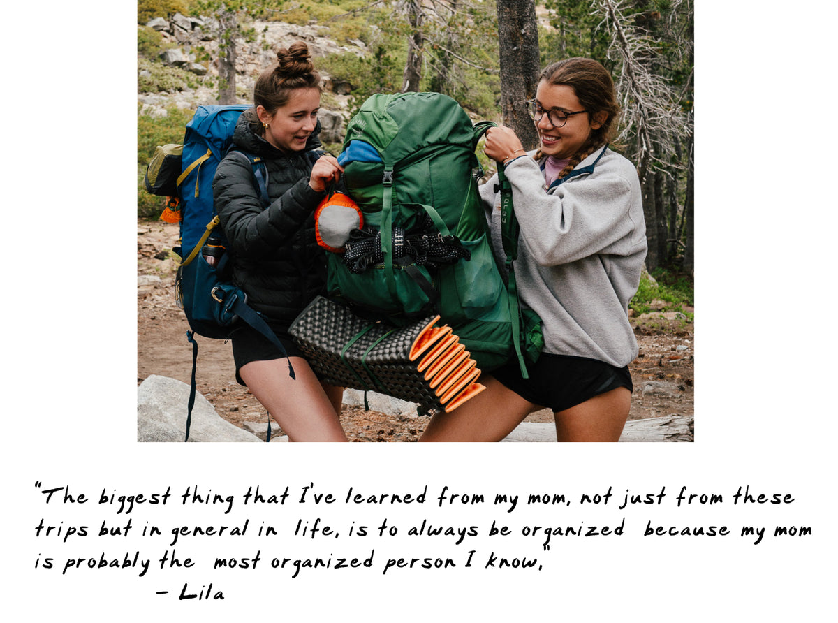 Two women hiking with large green and blue backpacks in a forest setting, with a handwritten quote printed below the photo.